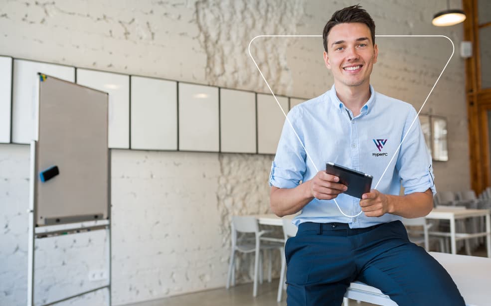 Persona del equipo de soporte de HyperPC sonriendo con una tablet en la mano, en una oficina